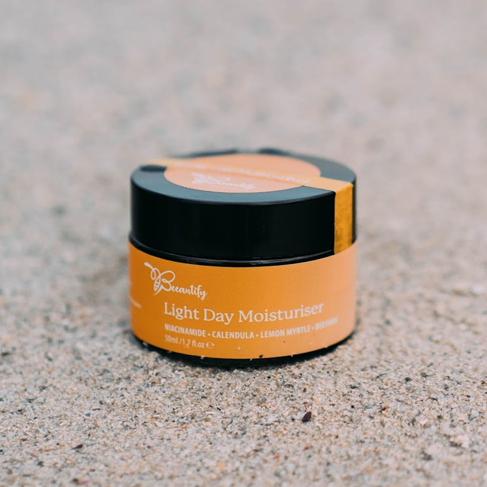 Jar of light day moisturizer on a textured surface