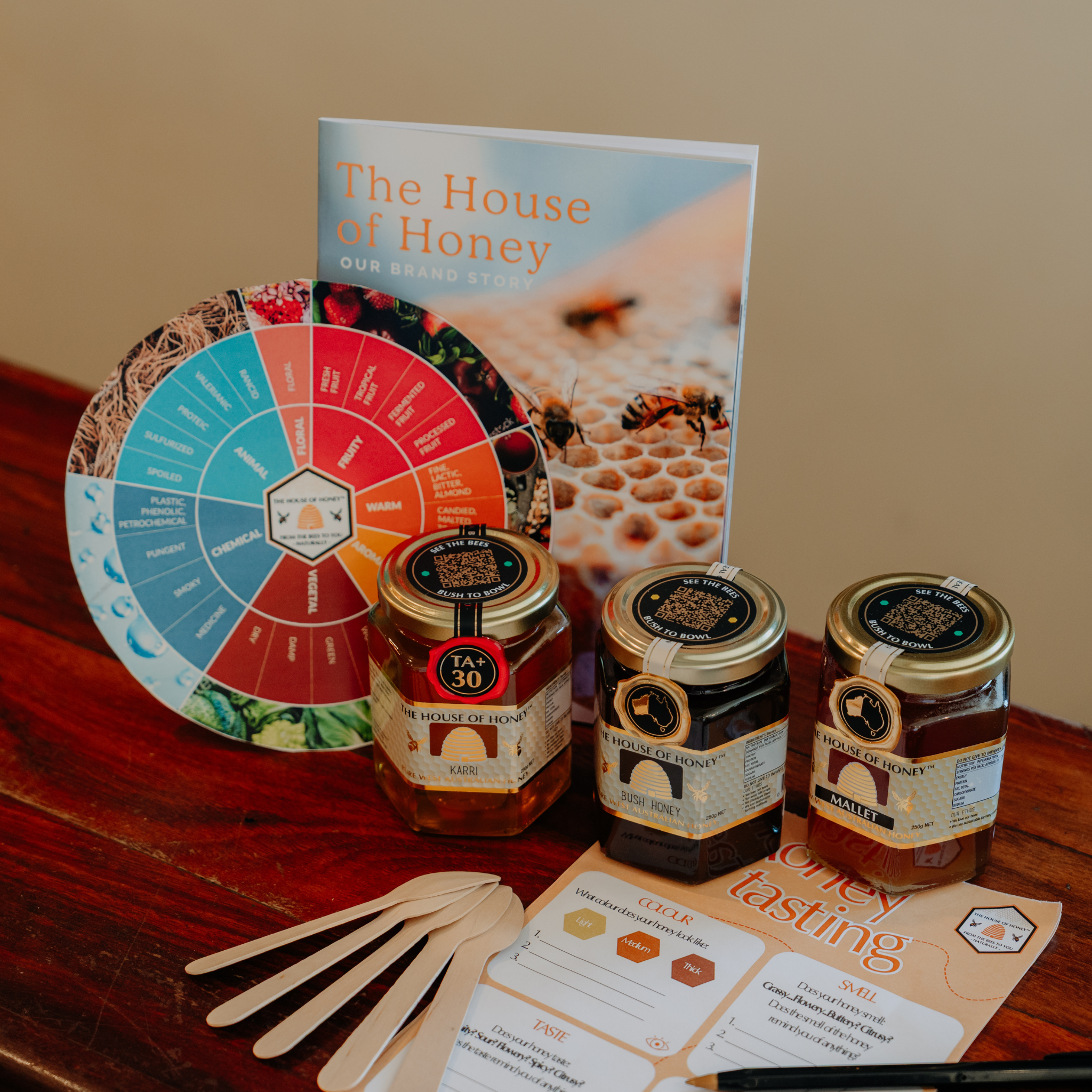 3 x 250g glass honeys, honey tasting kit pad, wooden spoons, honey tasting wheels and The House of Honey brand story