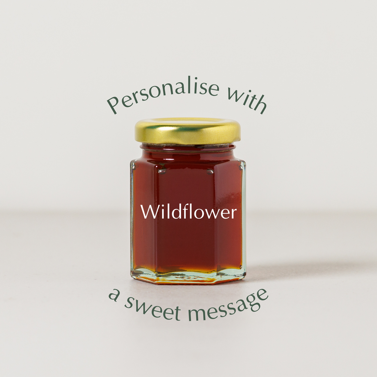 Jar of wildflower honey with a gold lid on a light background, featuring text about personalization.